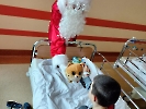 Mikołaj wręcza chłopcu pluszową maskotkę jeża.
