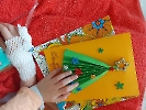 Kartka świąteczna z choinką i ręka dziecka.